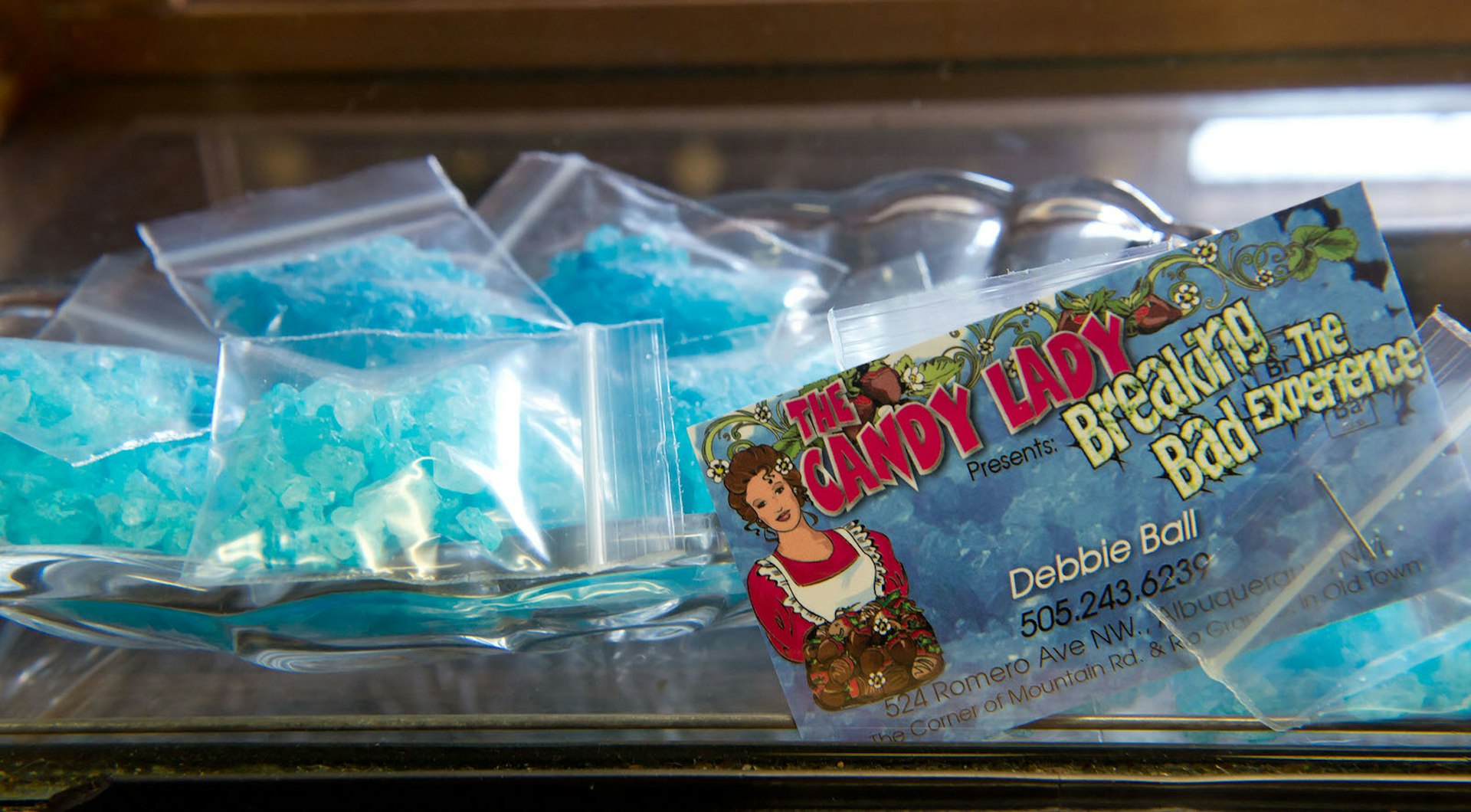 Bags of blue rock candy in small plastic bags sit on a counter