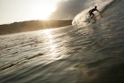 Features - A man Surfing down a barrel at sunset in Nicaragua