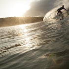 Features - A man Surfing down a barrel at sunset in Nicaragua