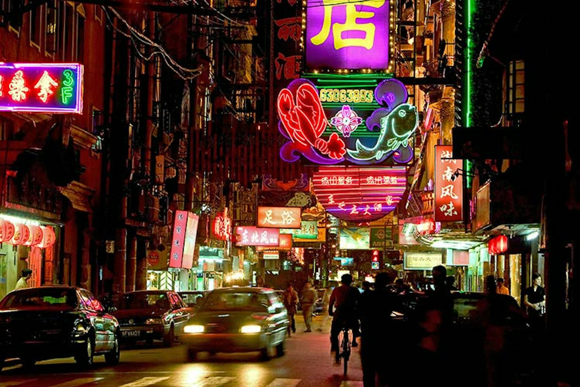 Restaurants, shops and massage parlours line the neon lanes of Shanghai's Hongkou quarter. Image by Karl Johaentges / Getty Images