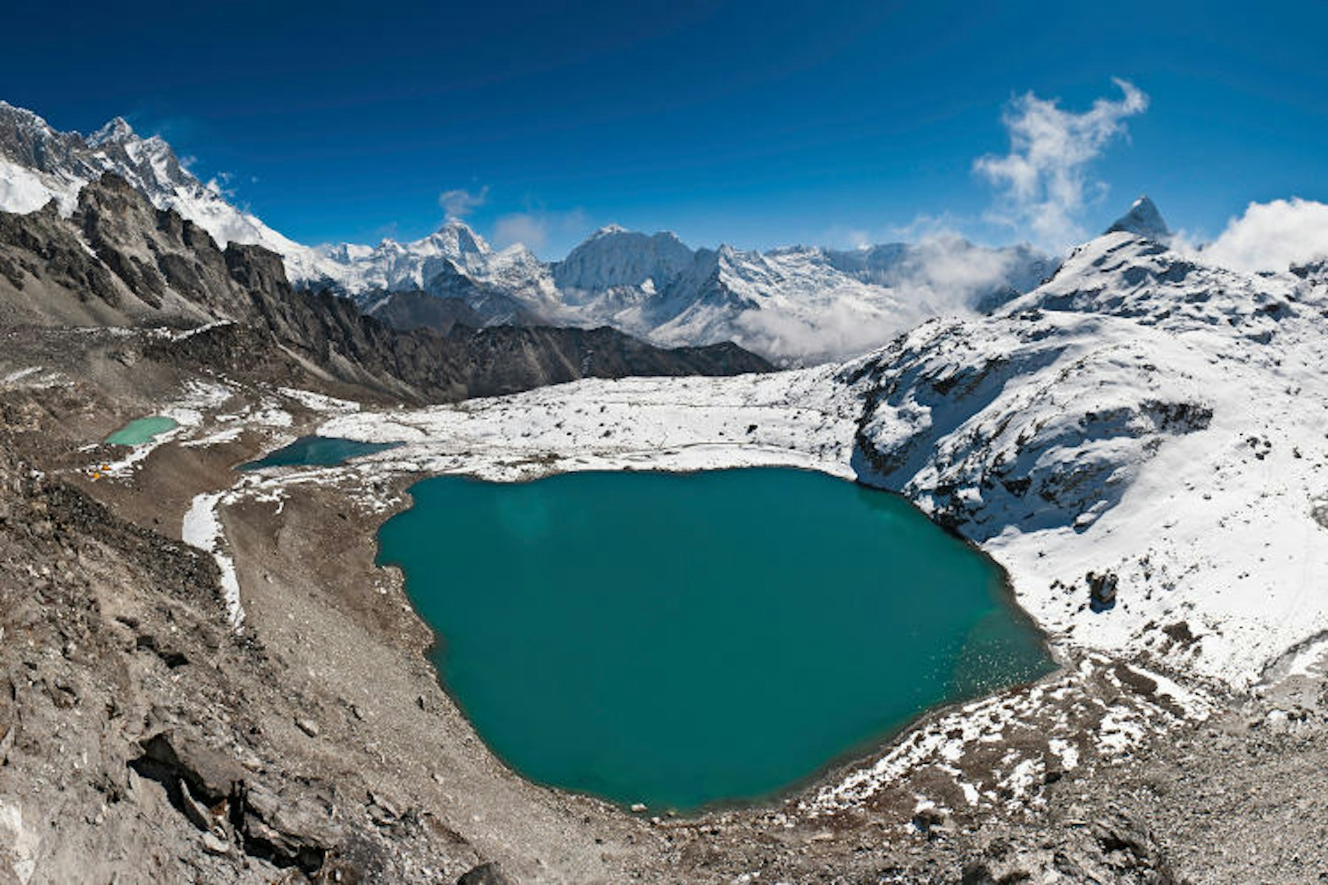 Mountain lake framed by snow at Kongma La. Image by fotoVoyager / Getty Images.