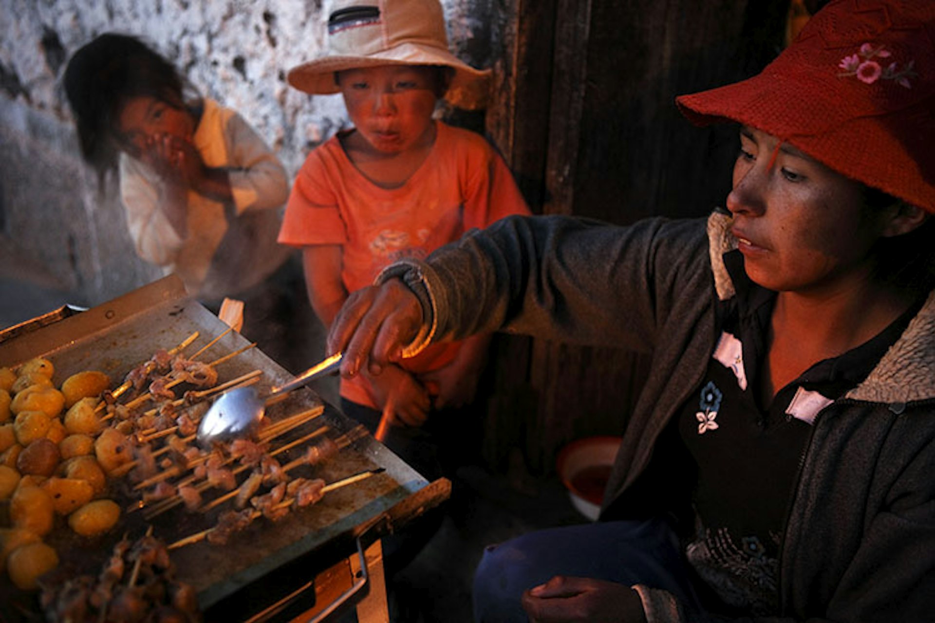 Woman grilling anticucho / Image by Johnny Haglund  / Photostock / Getty 