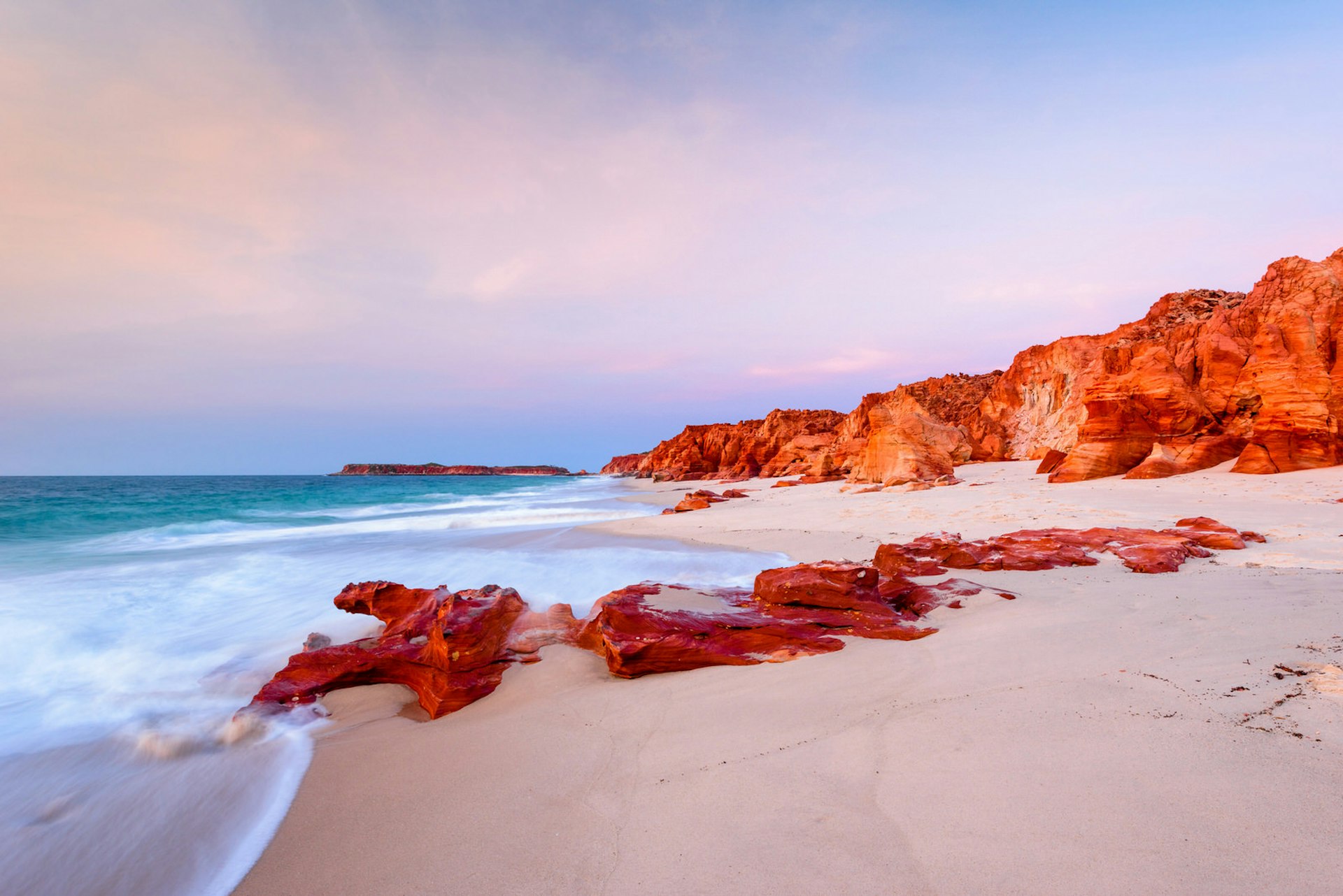 White sandy beach and red rock formations on the western side of Cape Leveque at dusk.