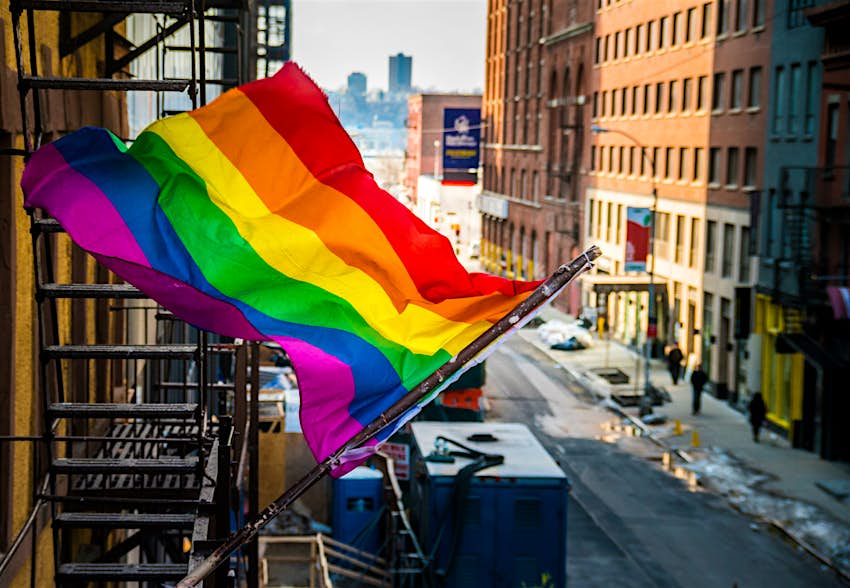 New York A rainbow flag waves outside a typical New York brownstone building with a fire escape.