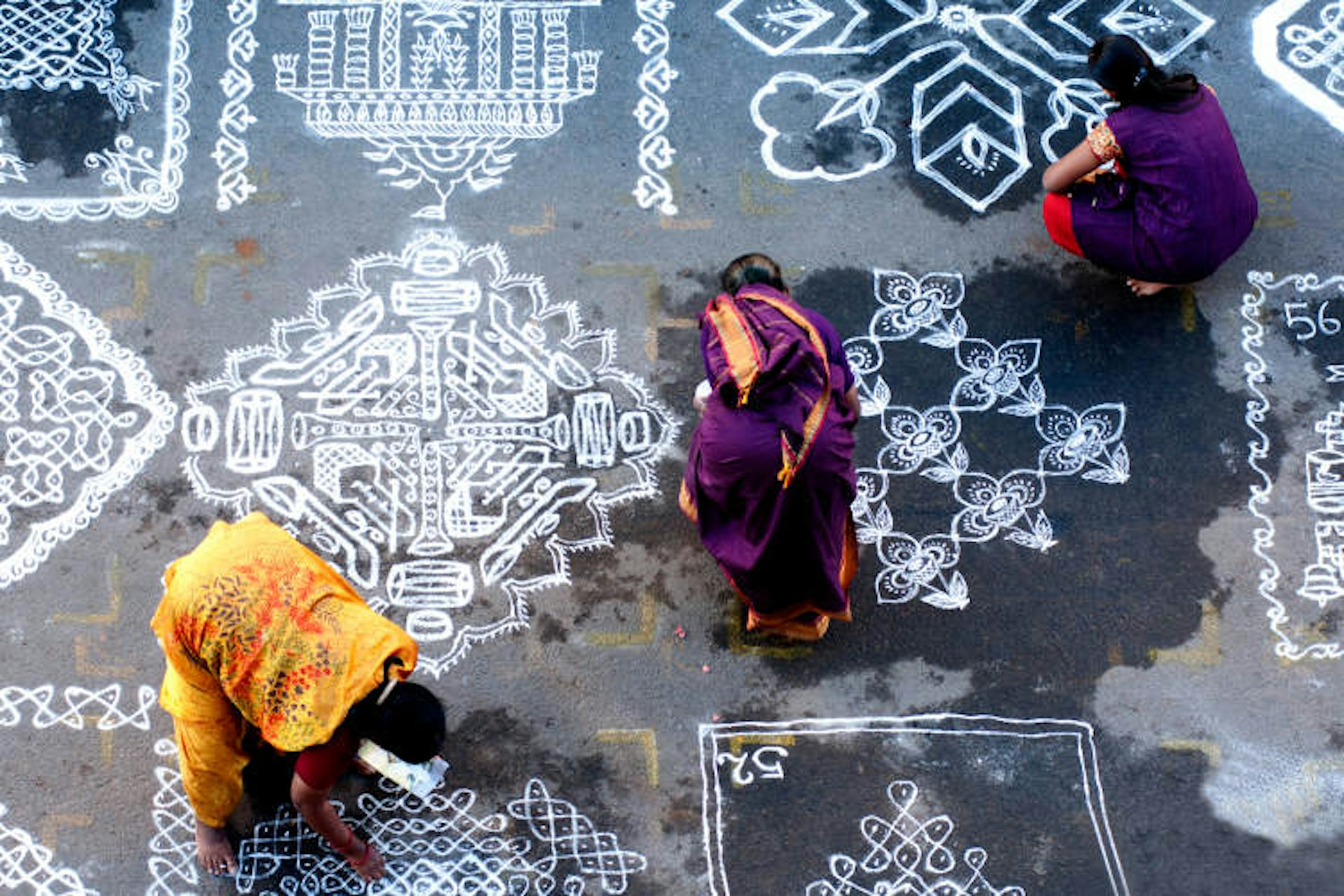 Women mark out rangoli patterns in Mylapore. Image by Srinivasa Krishnan / Getty Images.