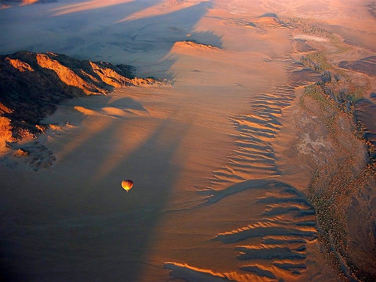 Namibia-balloon Shot from above, a ballooning moves over the dunescape of the Namib Desert.