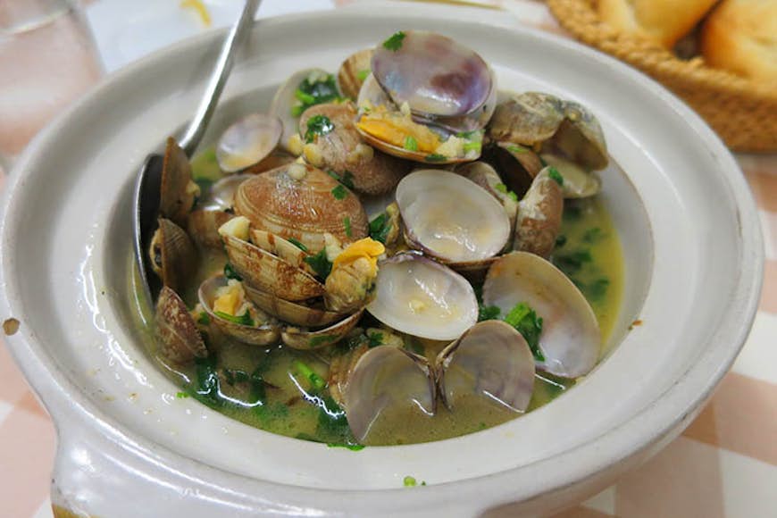 Macanese stir-fried clams. Image by Megan Eaves / Lonely Planet