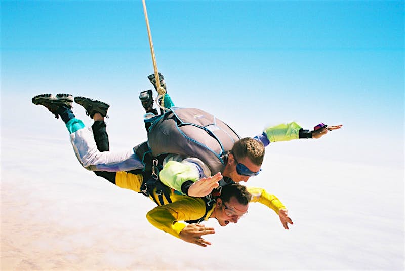 Two people skydiving together in tandem over the Namib Desert, Namibia.