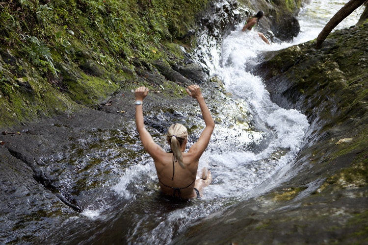 Happiness is riding a natural water slide on the island of Taveuni. Image by Justin Lewis / Getty Images