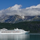 A cruise ship passes near Reid Glacier. Image by Michael Melford / The Image Bank / Getty