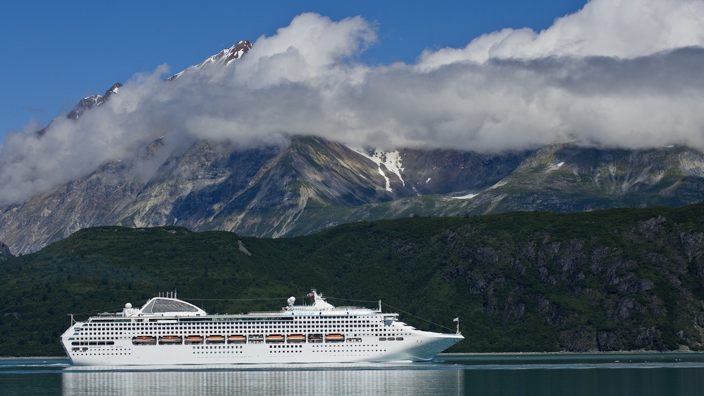 A cruise ship passes near Reid Glacier. Image by Michael Melford / The Image Bank / Getty