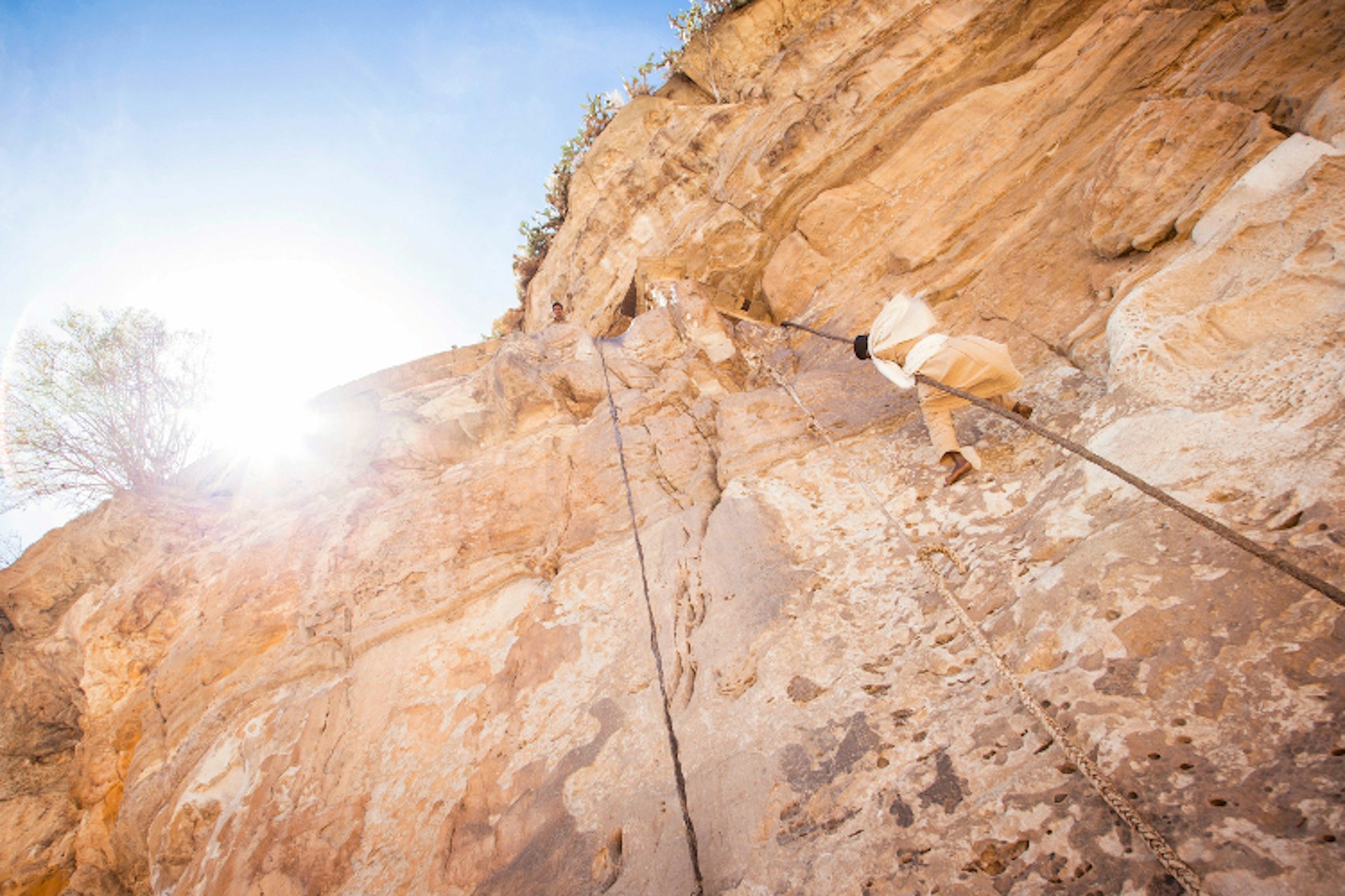 A monk climbs up to Debre Damo. Image by Philip Lee Harvey / Lonely Planet