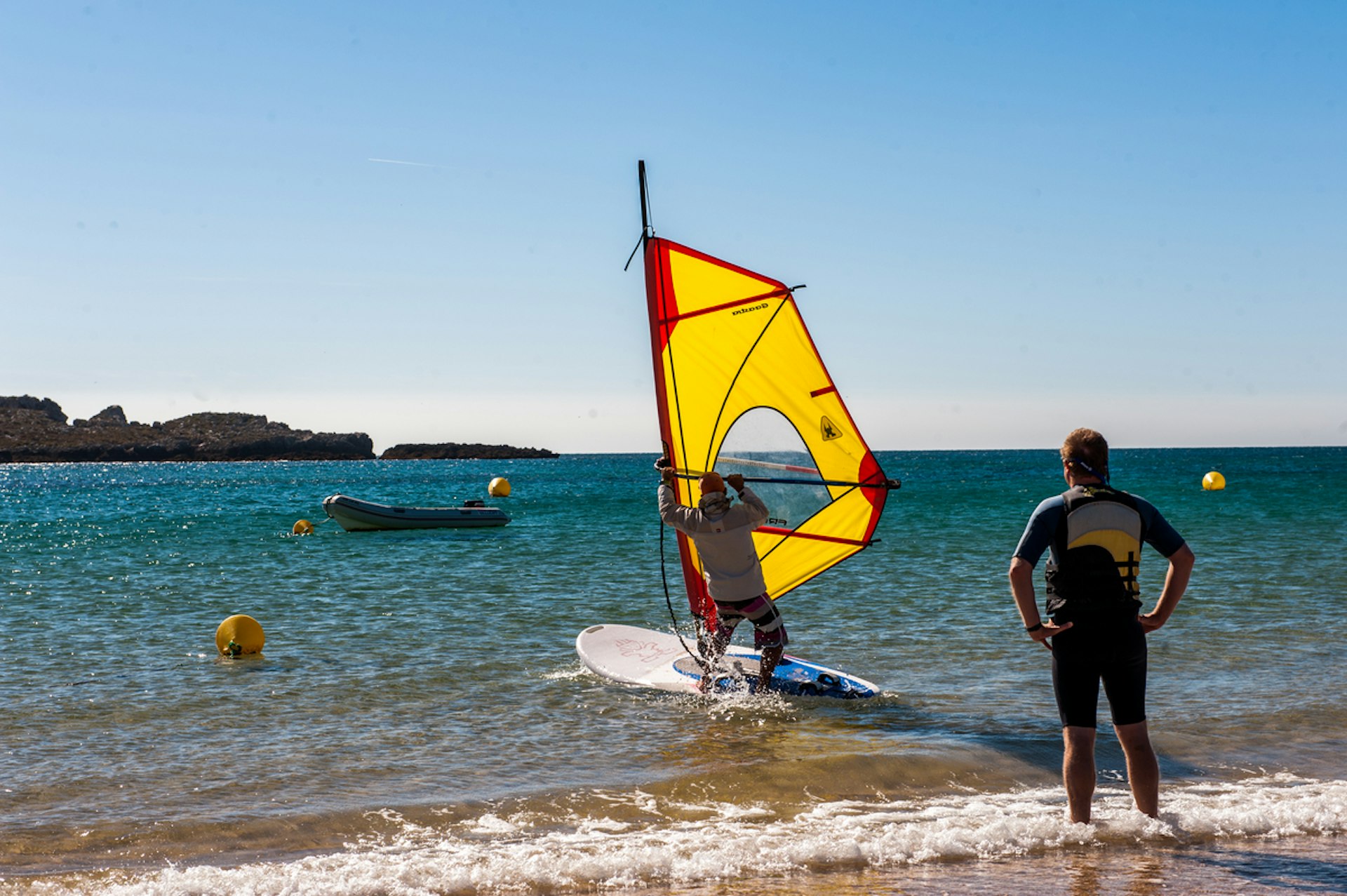 Windsurfers at Praia do Martinhal. Image by Lola Akinmade Åkerström / Lonely Planet