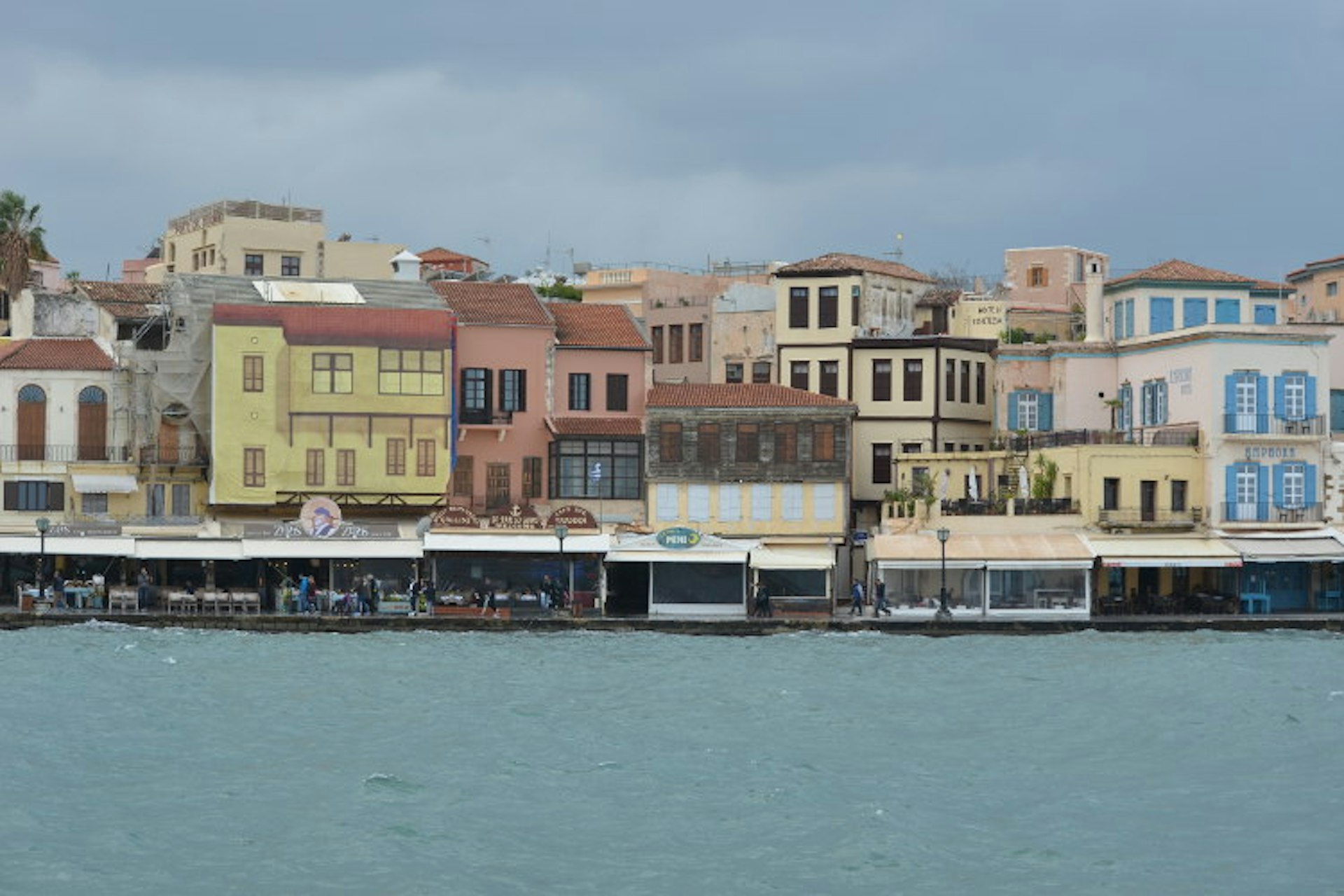 Grey-blue water butts up to the port, which is lined with pastel-coloured buildings