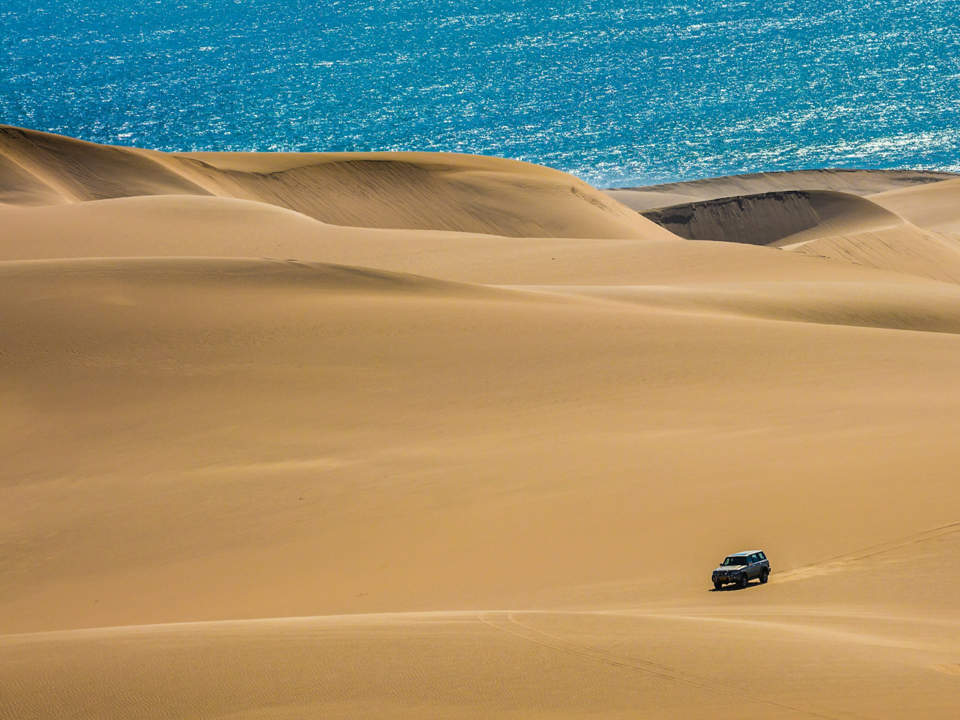 A 4WD driving over some dunes in Nambia © kavram / Shutterstock