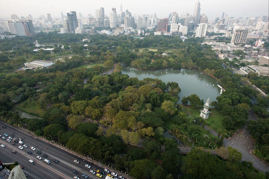 High view of Lumphini Park, large leafy park bordered by city buildings © Austin Bush / Lonely Planet