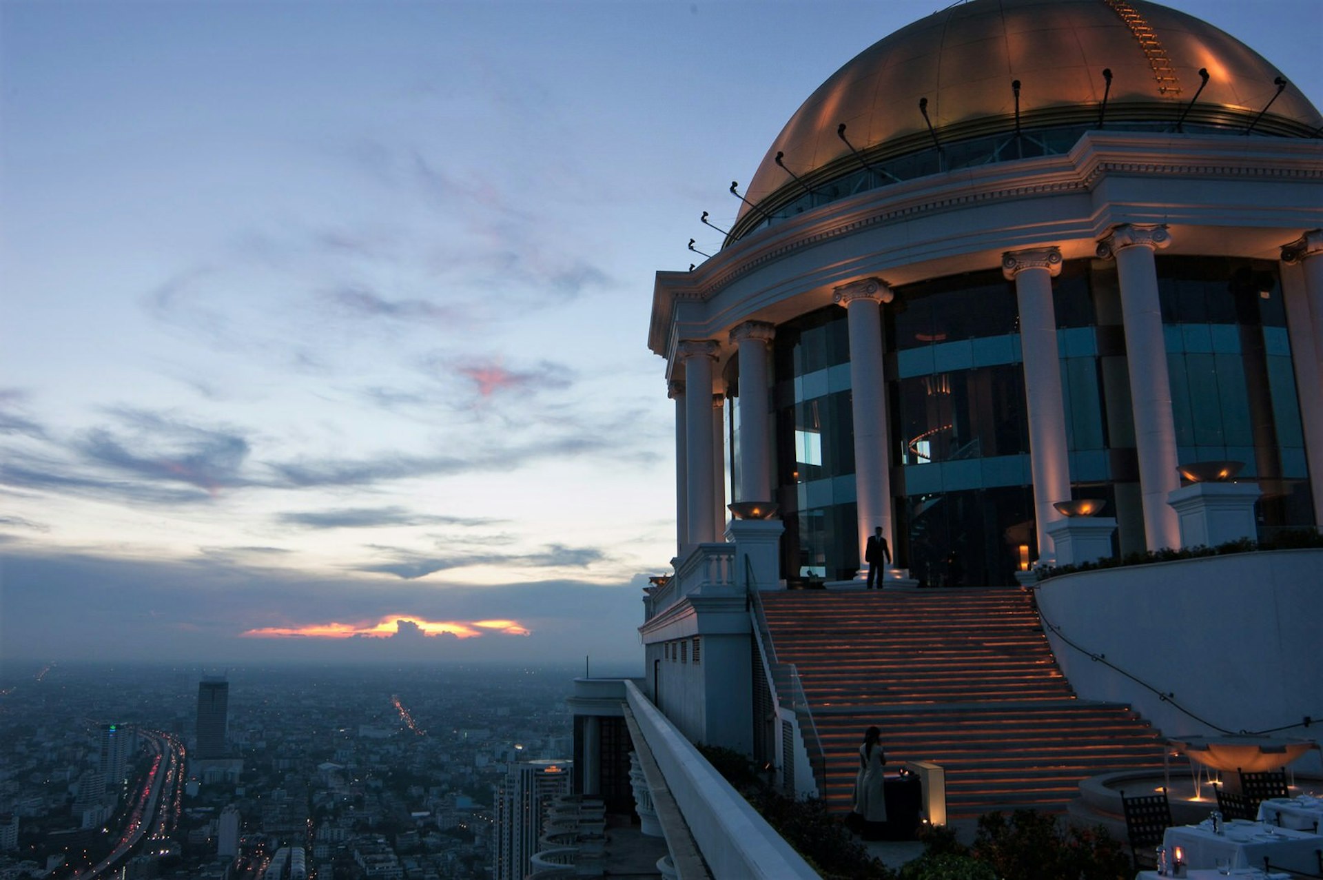 View at dusk of the Sky Bar staircase,, jutting out over the city © Austin Bush / Lonely Planet