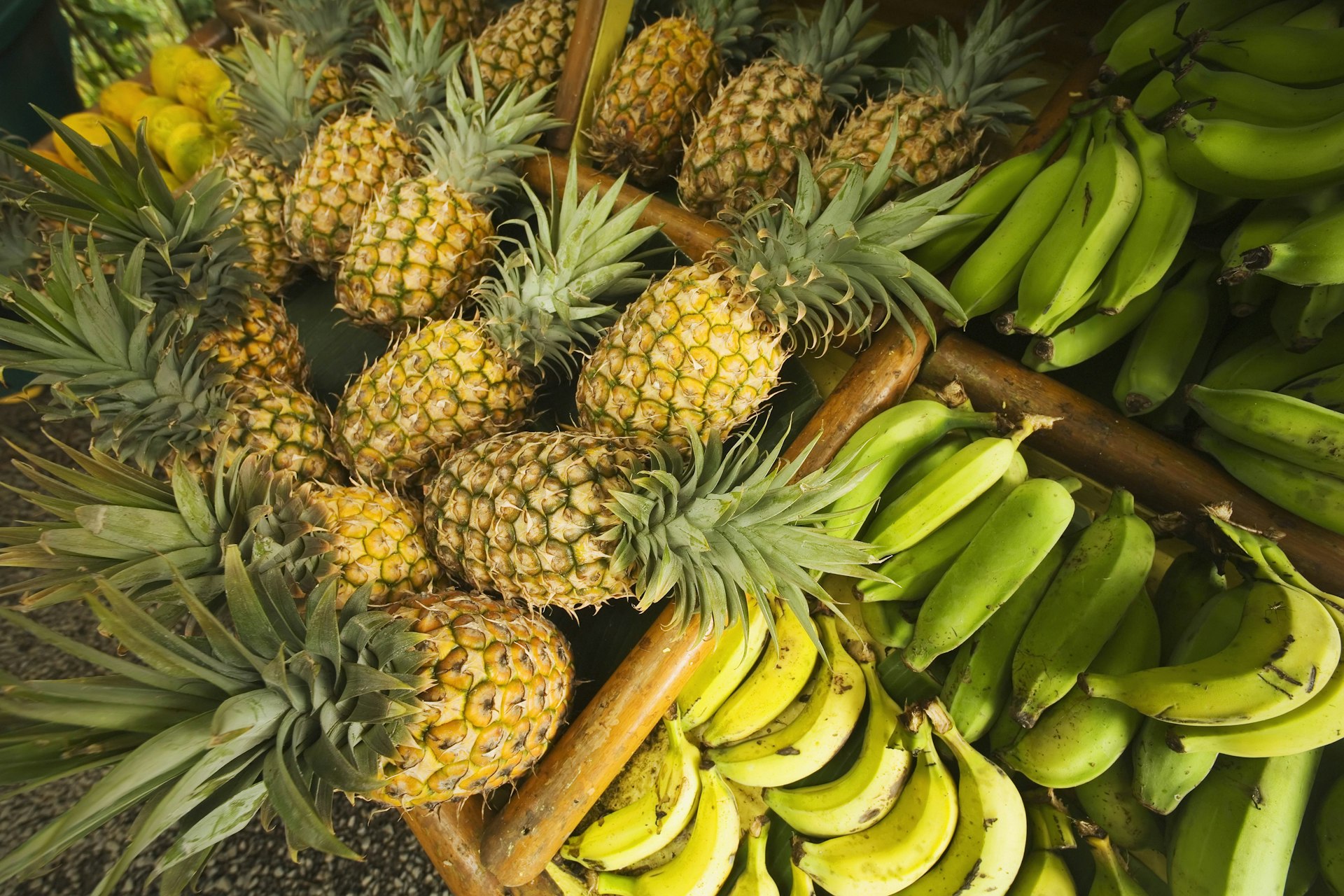 Pineapples and bananas at a fruit stand in Maui. Image by Ron Dahlquist / Design Pics / Perspectives / Getty