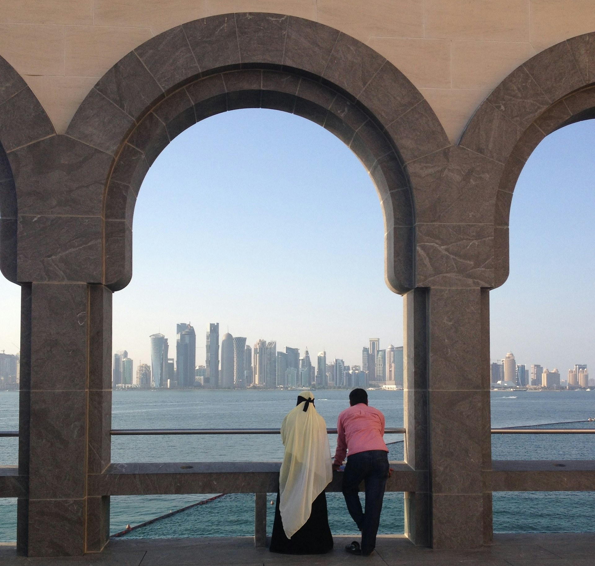 A couple admire the skyline from outside the Museum of Islamic Art, Doha, Qatar. Image by Helen Elfer  / Lonely Planet