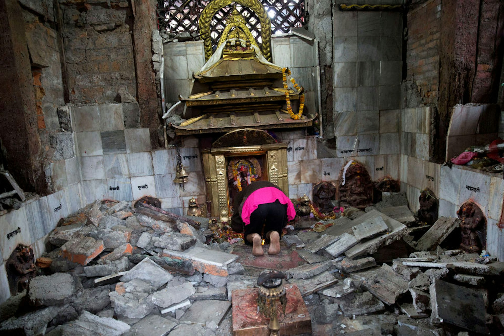 Woman praying in ruins of Kathmandu's Indrayani Temple.