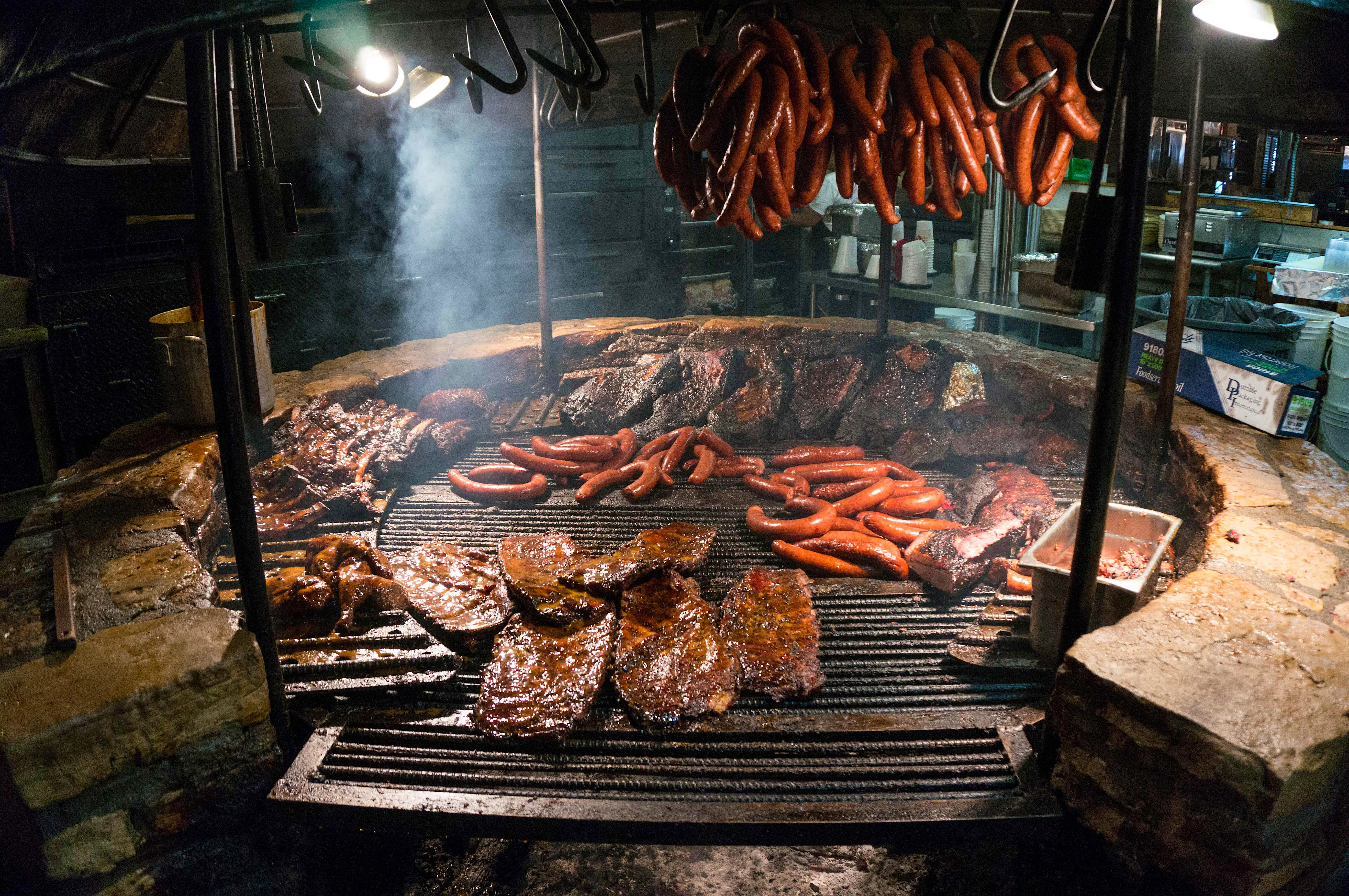 Features - 13339243644_46001eb312_o A variety of meats being prepared on The Salt Lick’s barbecue. Image by Anthony Quintano / CC BY 2.0