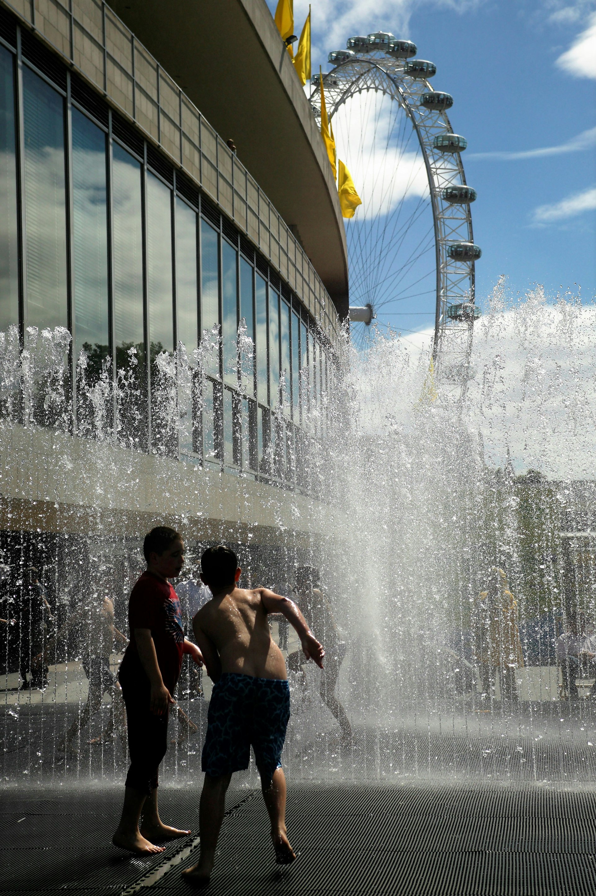 Children splashing in the fountains outside the Royal Festival Hall, London.