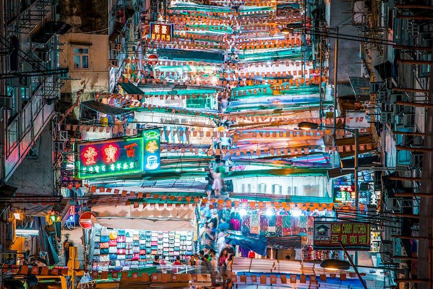 En overhead fotograferade många starkt upplysta shoppingstånd på en gatumarknad i Mong Kok, Hong Kong.