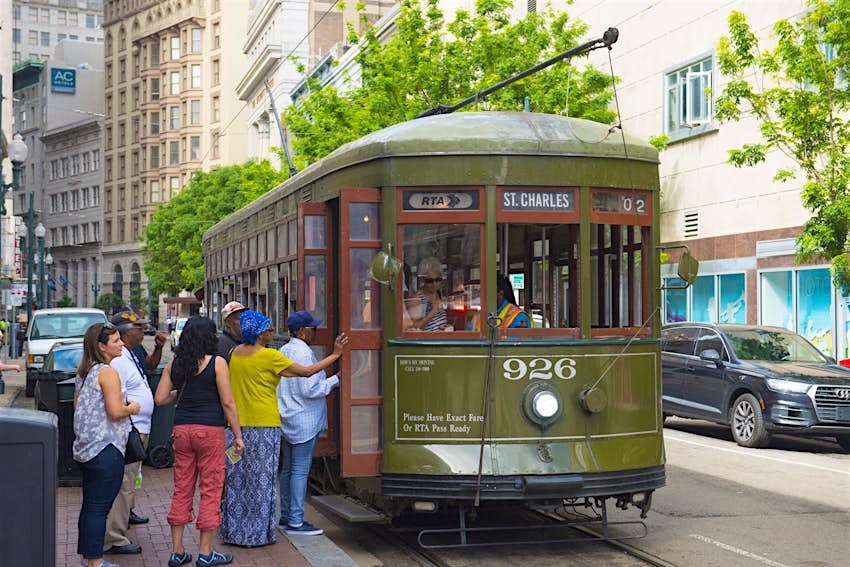 People board an olive green antique streetcar at St. Charles Line Route 12 on Canal Street in downtown New Orleans. The streetcar is the perfect way to get around during a New Orleans weekend. 