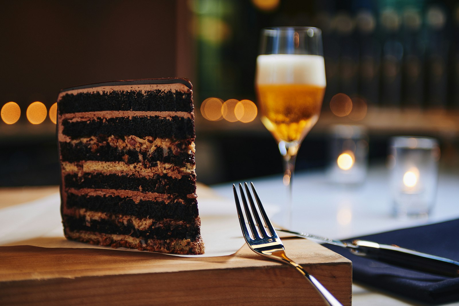 multilayered german chocolate cake served with a beer in a wine glass at Moody Tongue in Chiicago