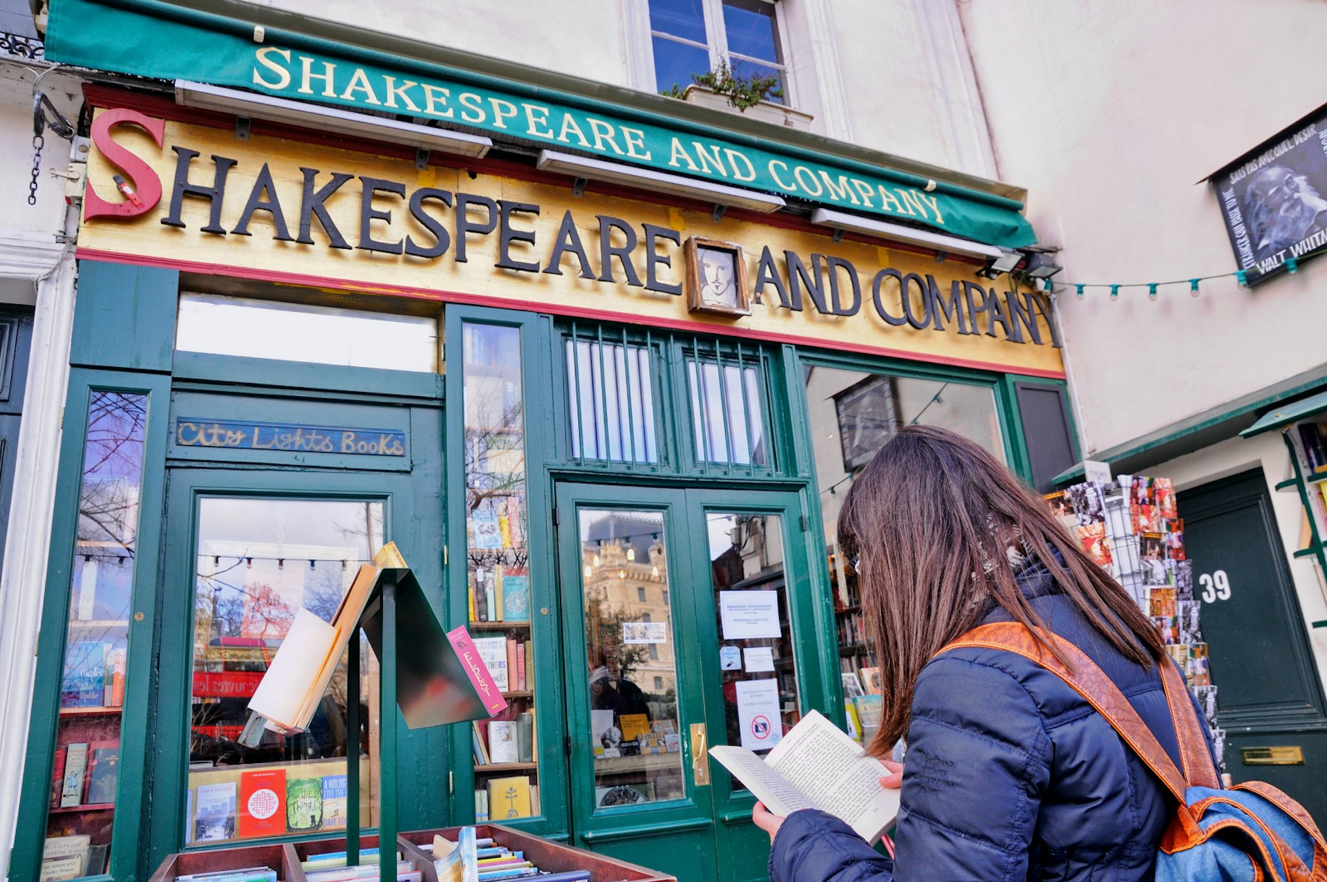 A woman reads a book outside Shakespeare and Company bookstore in Paris