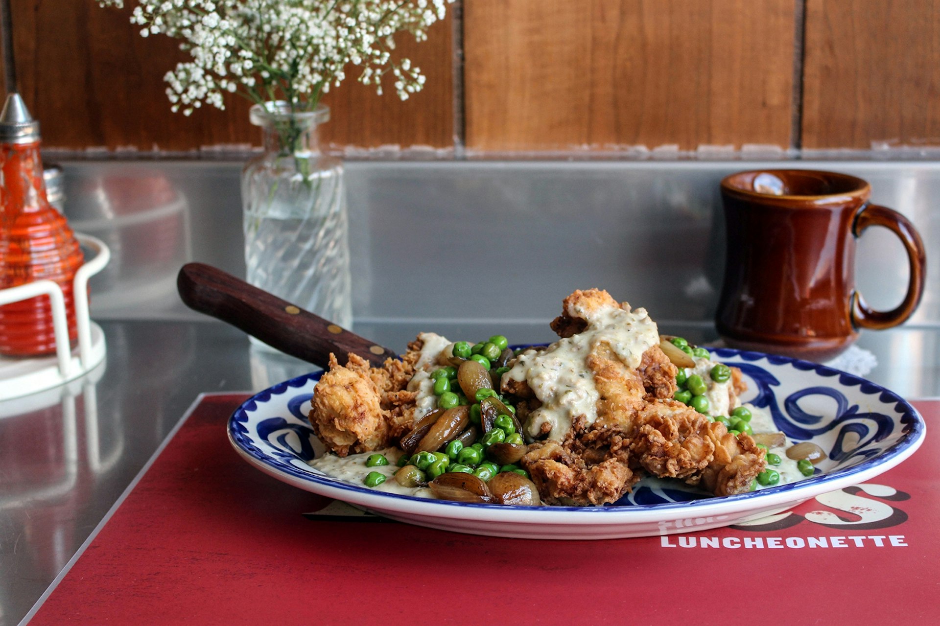 blue china plate heaped with chicken, gravy and peas at dove's luncheonette in Chicago