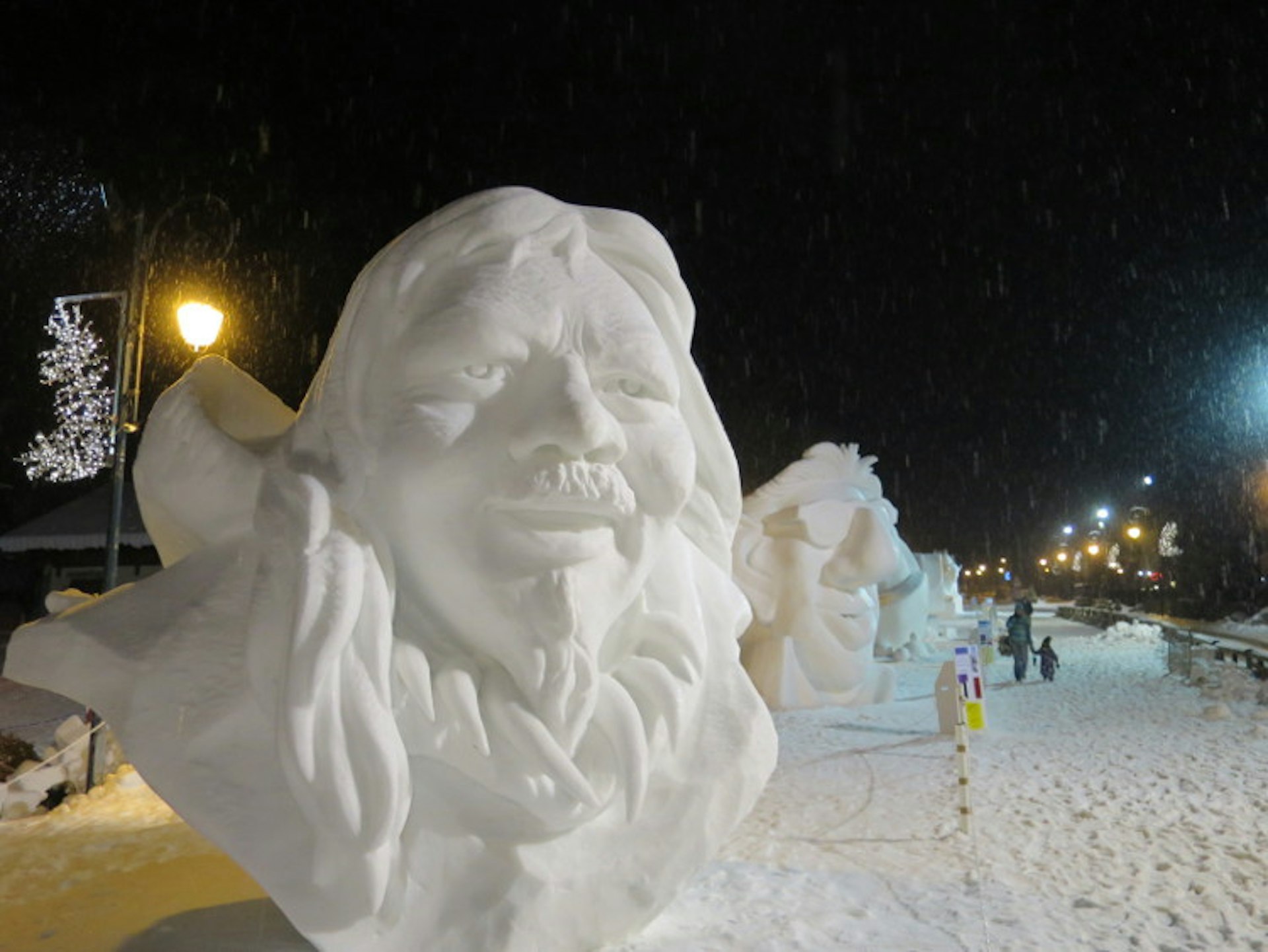 A giant sculpture of a man's head, made out of ice, sits in the snowy main street of the village of Valloire, France.