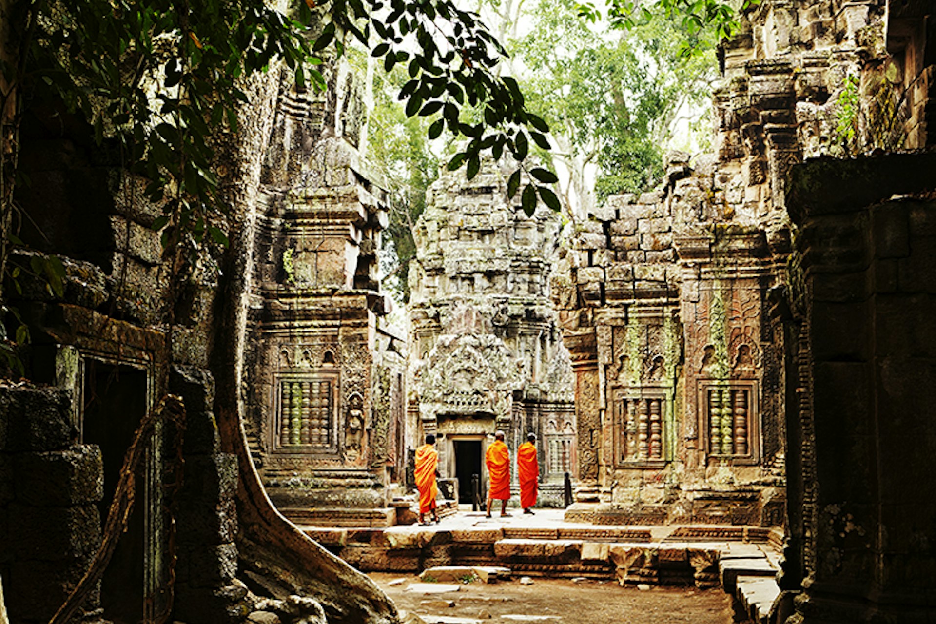 Monks wandering through temple ruins of Ta Prohm.