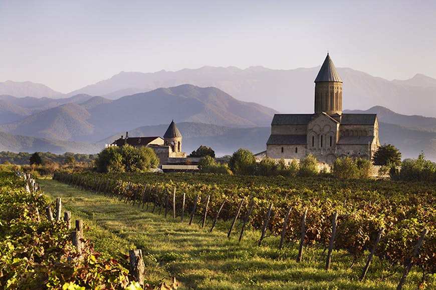 Vineyard and Alaverdi Cathedral with Caucasus Mountains in background.