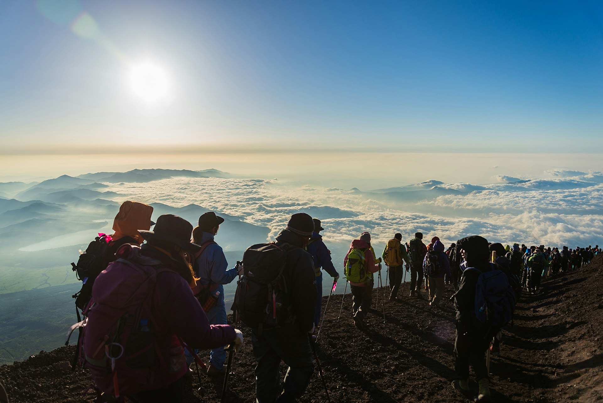 Hikers gather above the clouds on the summit of Mt Fuji; Best things to do in summer in Japan 