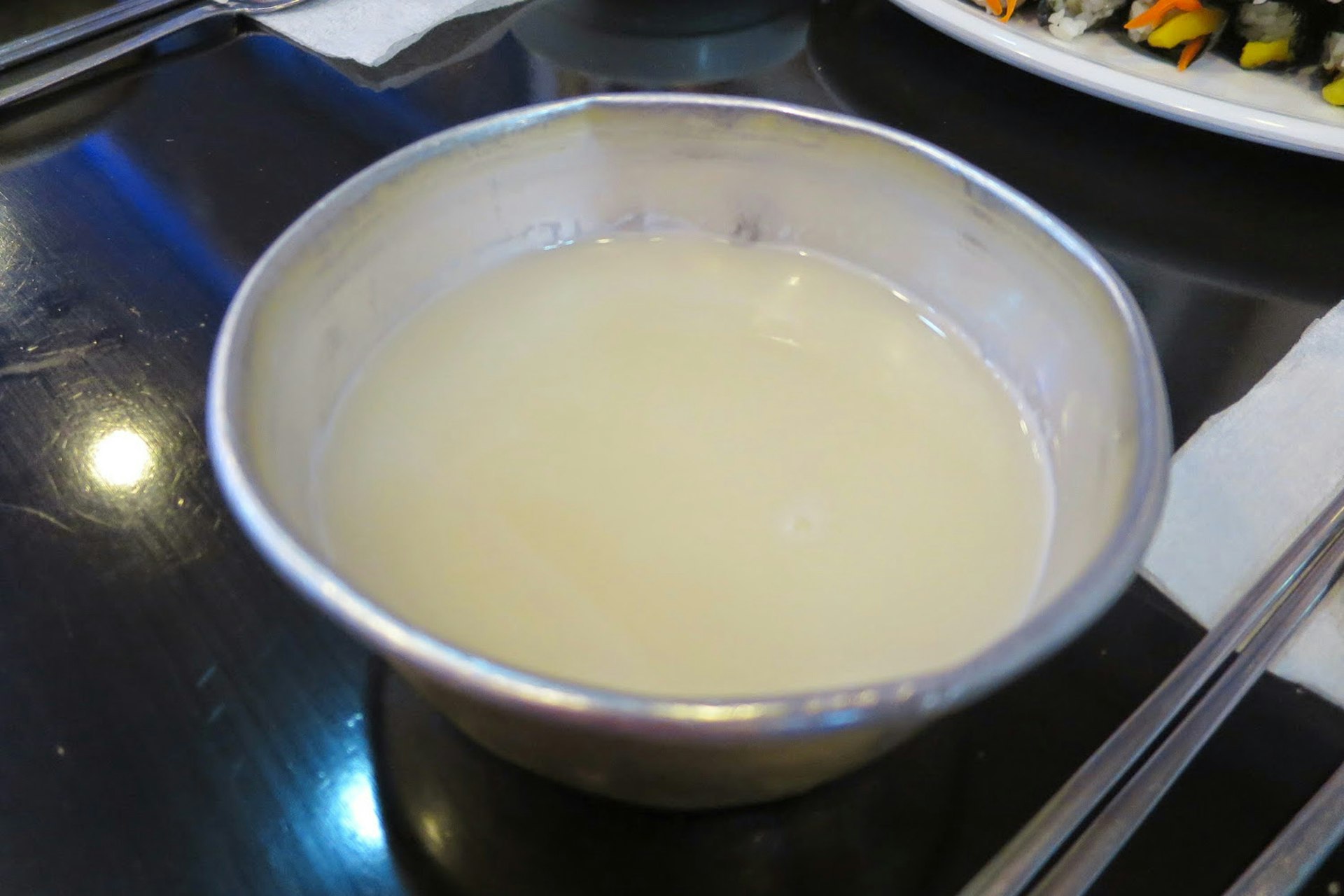 Makgeolli is often drunk out of a tin or brass cup. Image by Megan Eaves / Lonely Planet