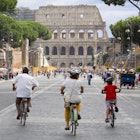 Cycling down Via del Fori Imperiali towards the Colosseum.