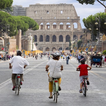 Cycling down Via del Fori Imperiali towards the Colosseum.