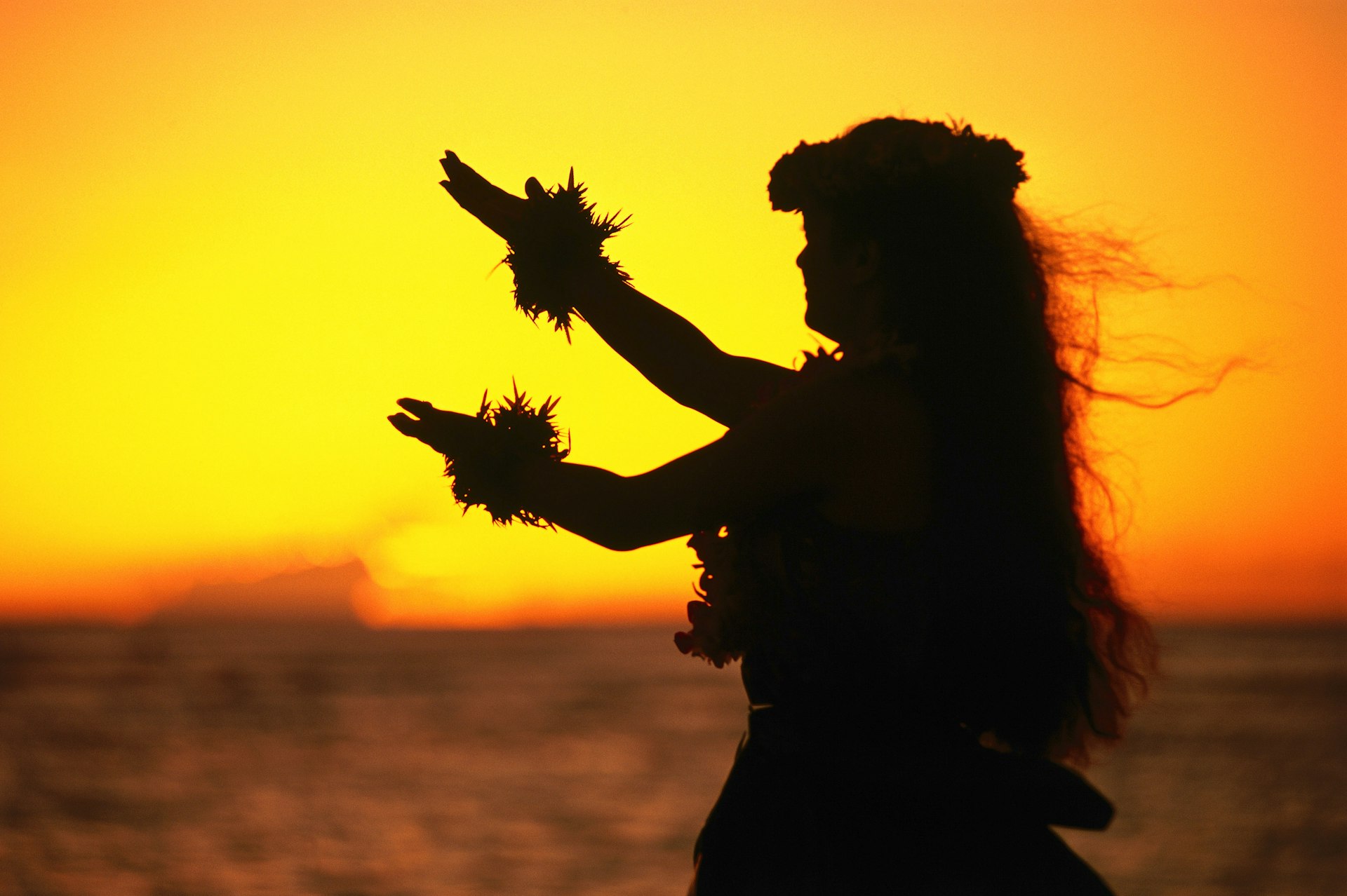 Hula dancer at sunset. Image by Ann Cecil / Lonely Planet Images / Getty