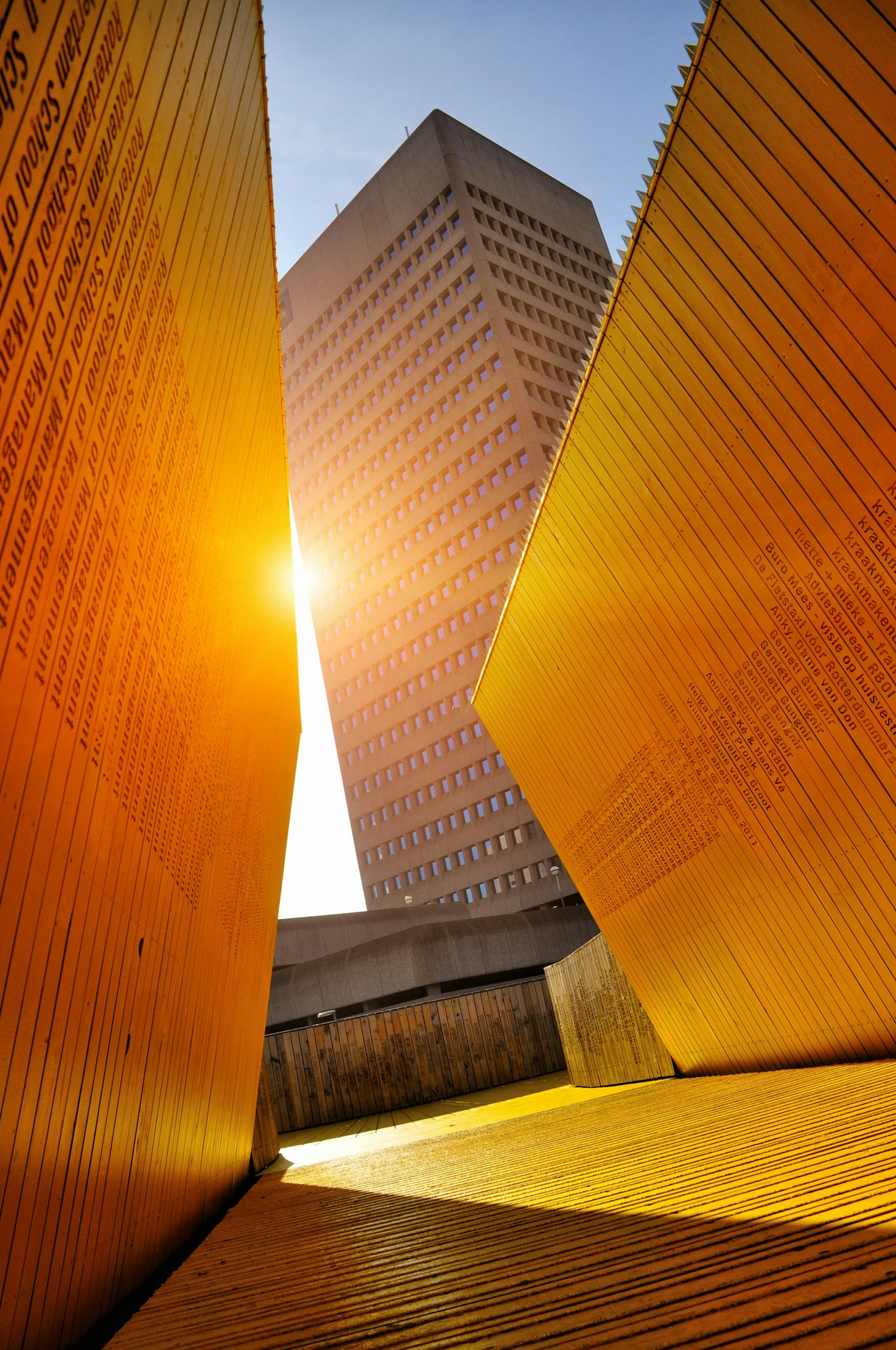 A skyscraper as seen from the bright yellow Luchtsingel pedestrian bridge in Rotterdam