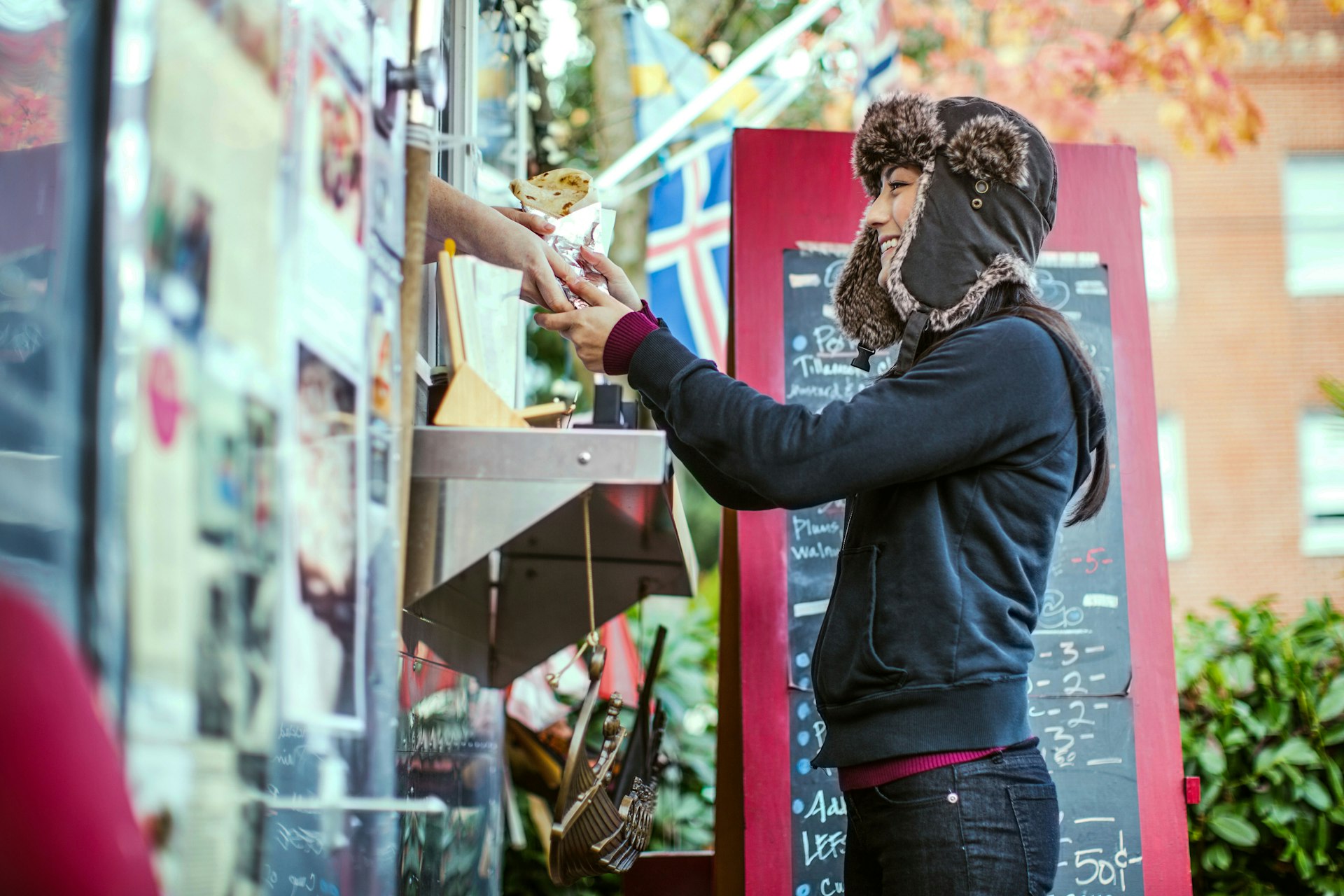 A woman orders a meal at a Portland food truck. Image by RyanJLane / Getty