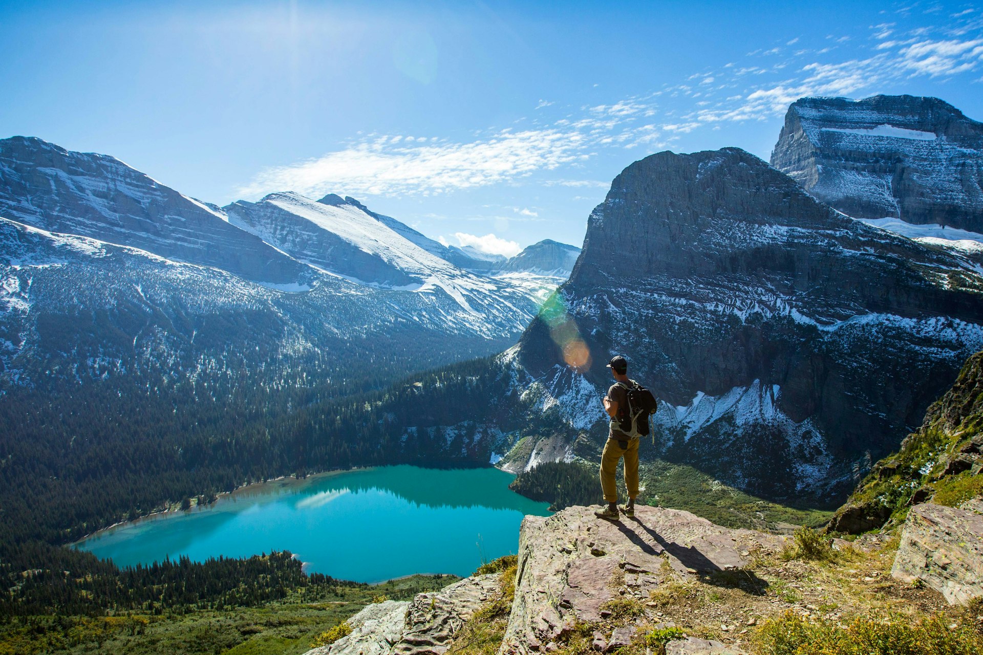 A man looks over a turquoise lake in Glacier National Park. Image by Jordan Siemens / Taxi / Getty