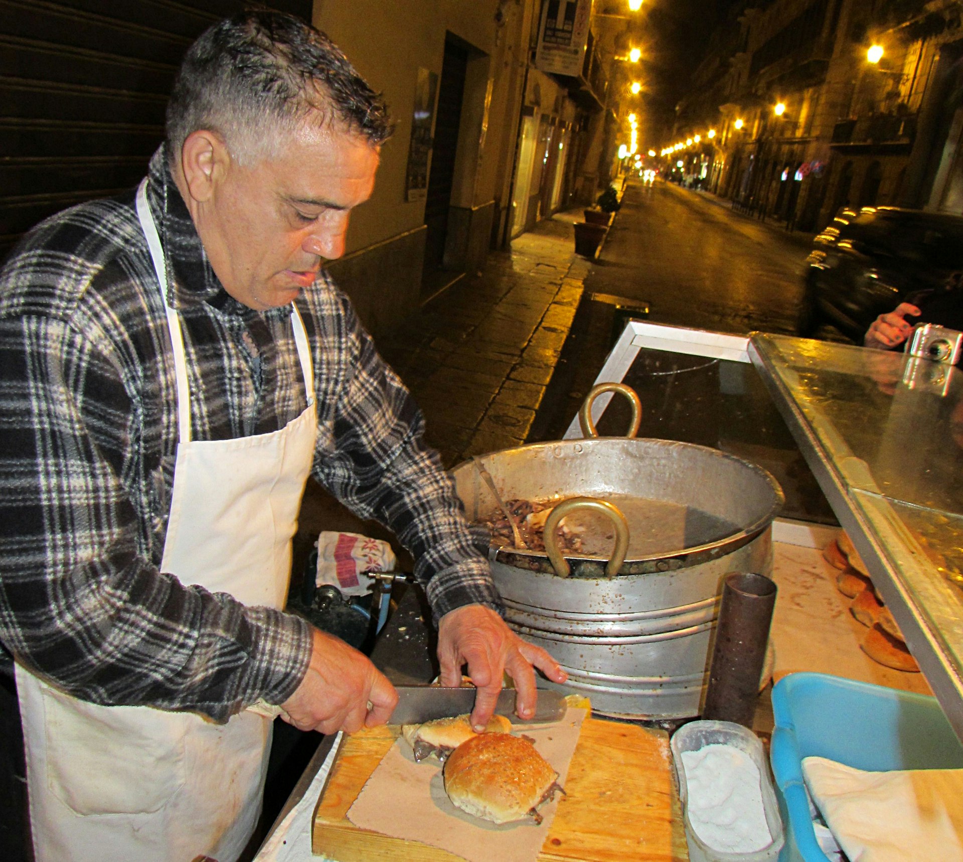 Rocky Basile, the 'King of Vucciria', prepares pani ca meusa. Image by Gregor Clark / Lonely Planet