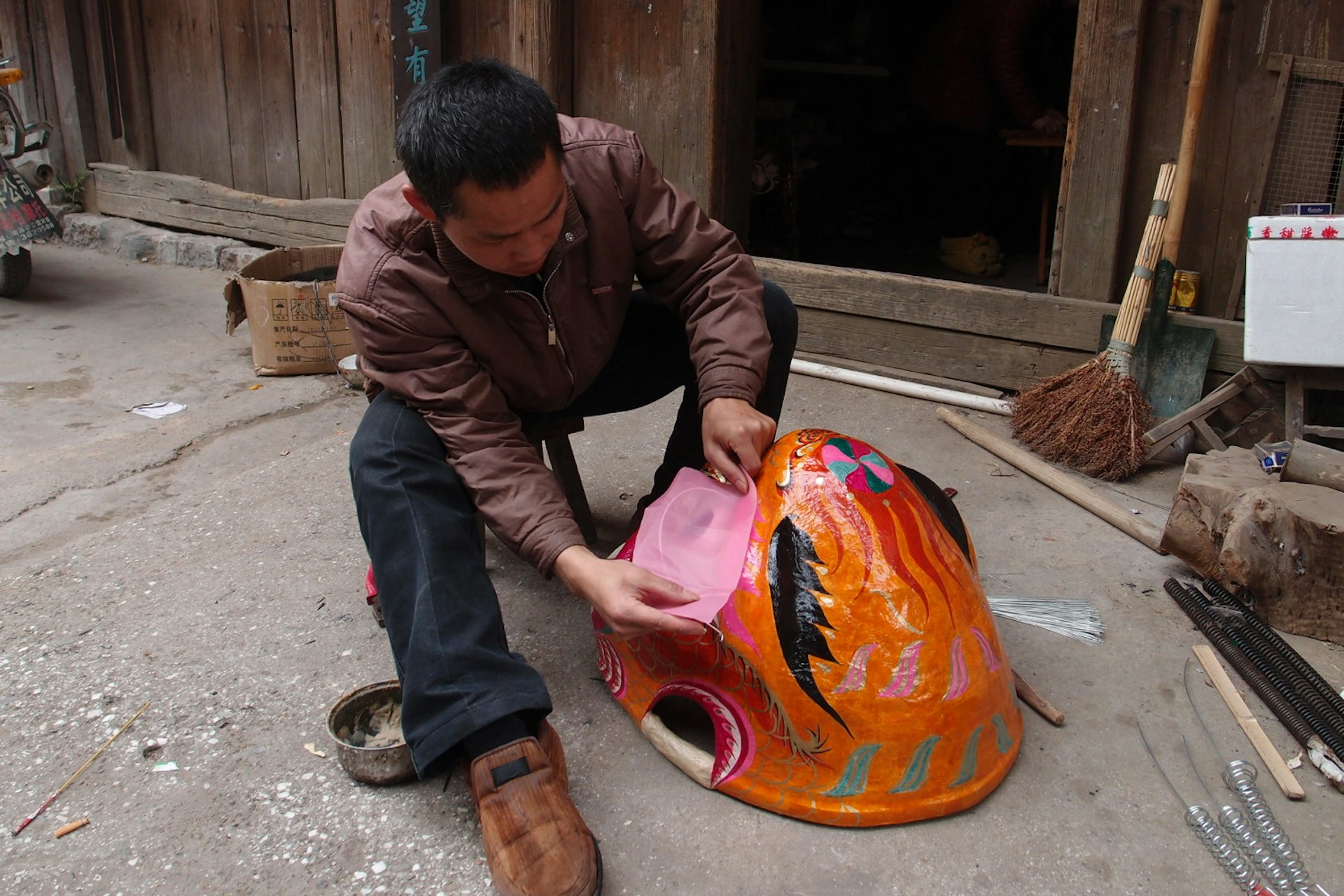 Daxu craftsman putting the finishing touches on a papier mache lion's head. Image by Piera Chen / Lonely Planet