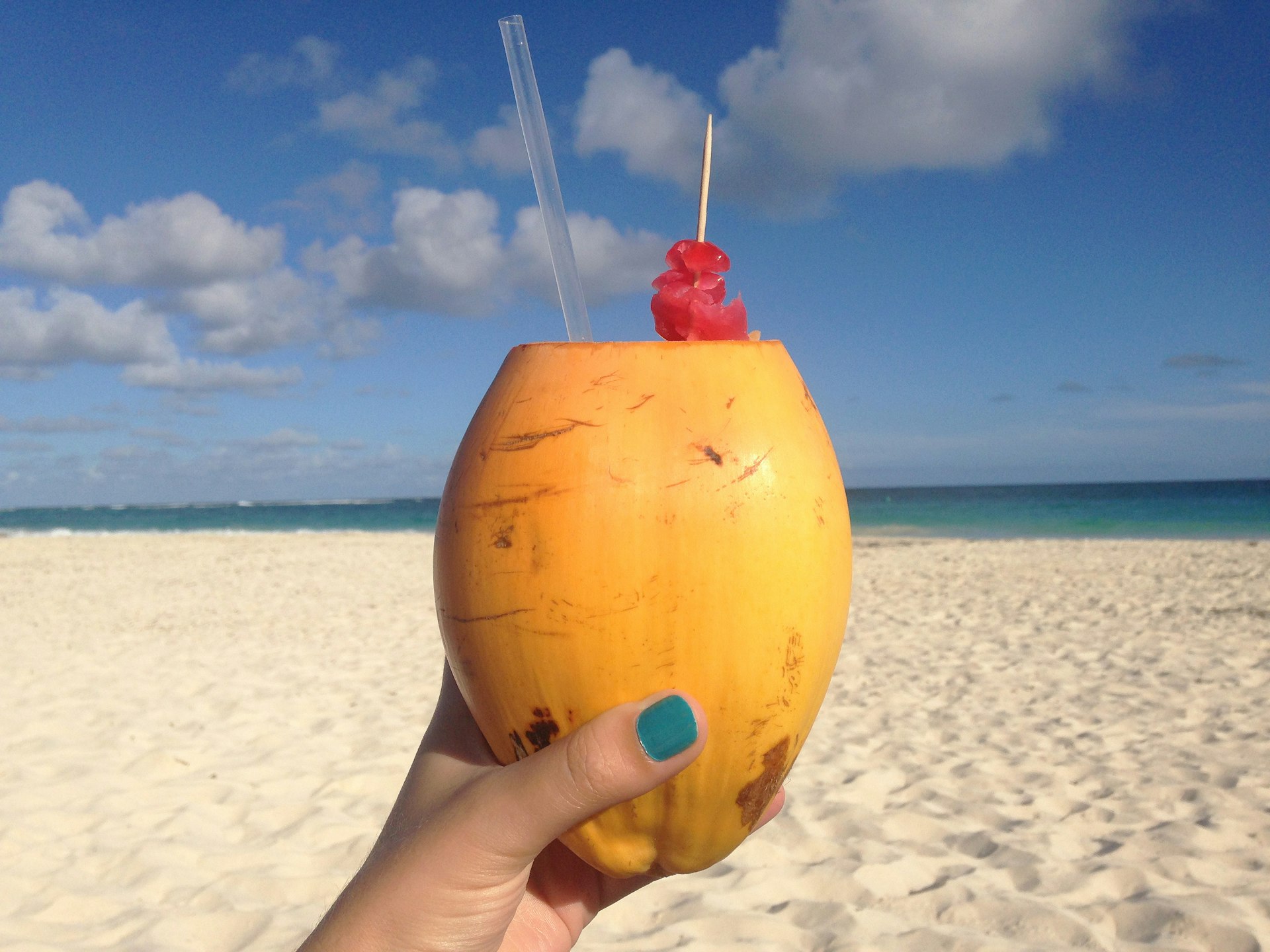 Coconut rum cocktail served on the beach in Barbados. Image by Sarah Reid / Lonely Planet
