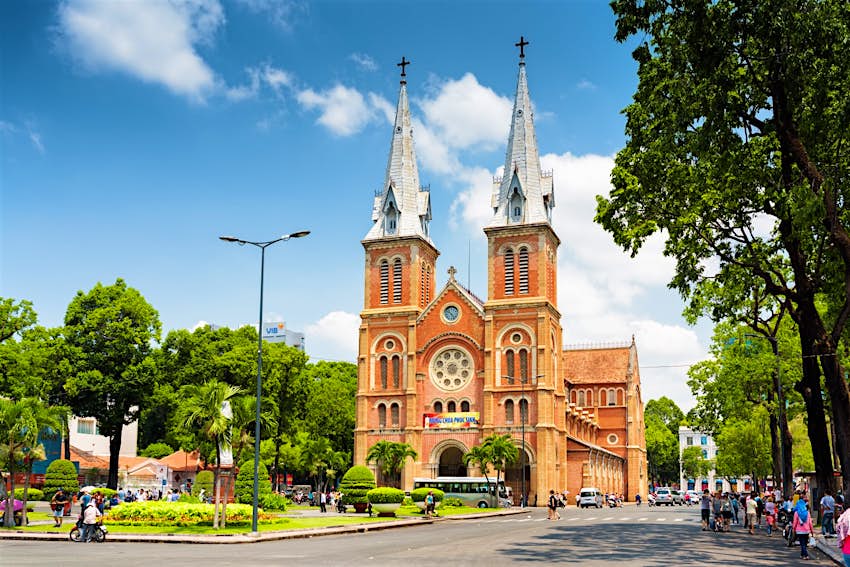 Features - HCMC-notre-dame-cathedral HCMC's Notre Dame Cathedral and the leafy surrounding square and street on a sunny, clear day © Efired / Shutterstock