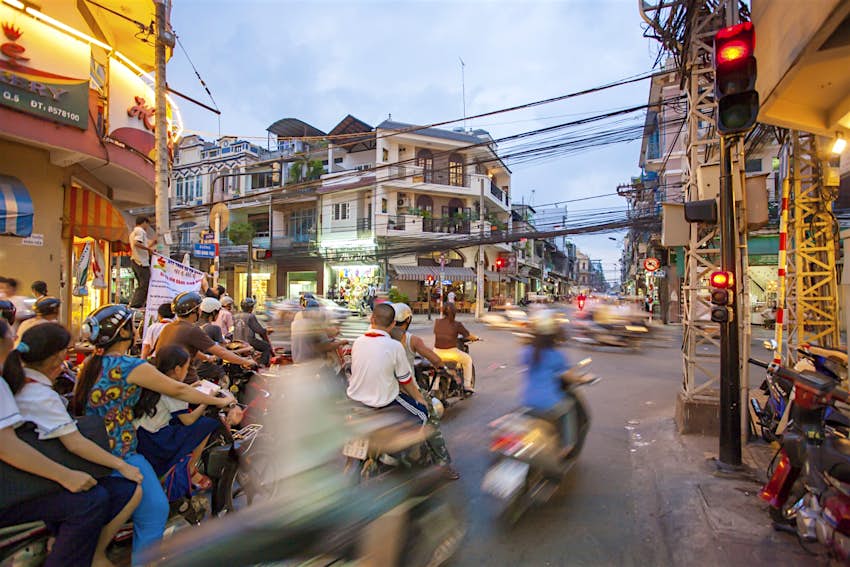 A busy street in HCMC with a crowd of scooters passing by in a blur