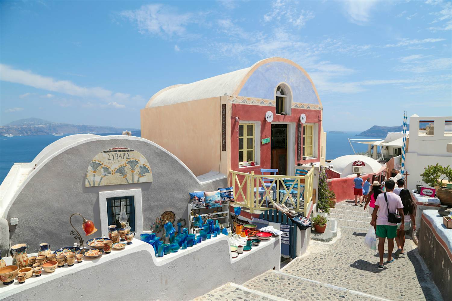Picturesque alleys of Oia village lined with domed buildings selling souvenirs.