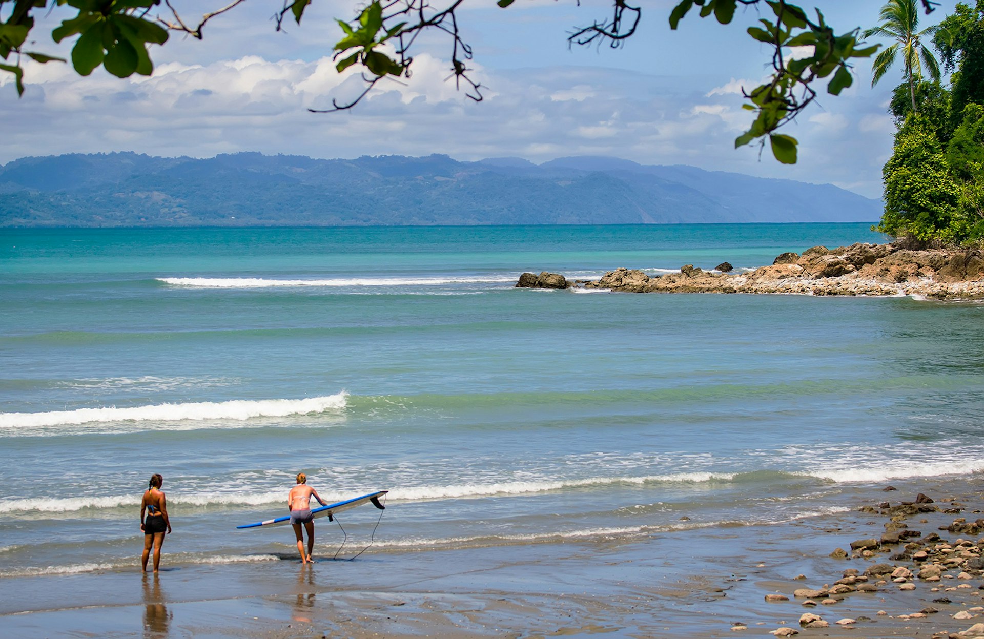 Two surfers on the beach on Osa Peninsula, Costa Rica