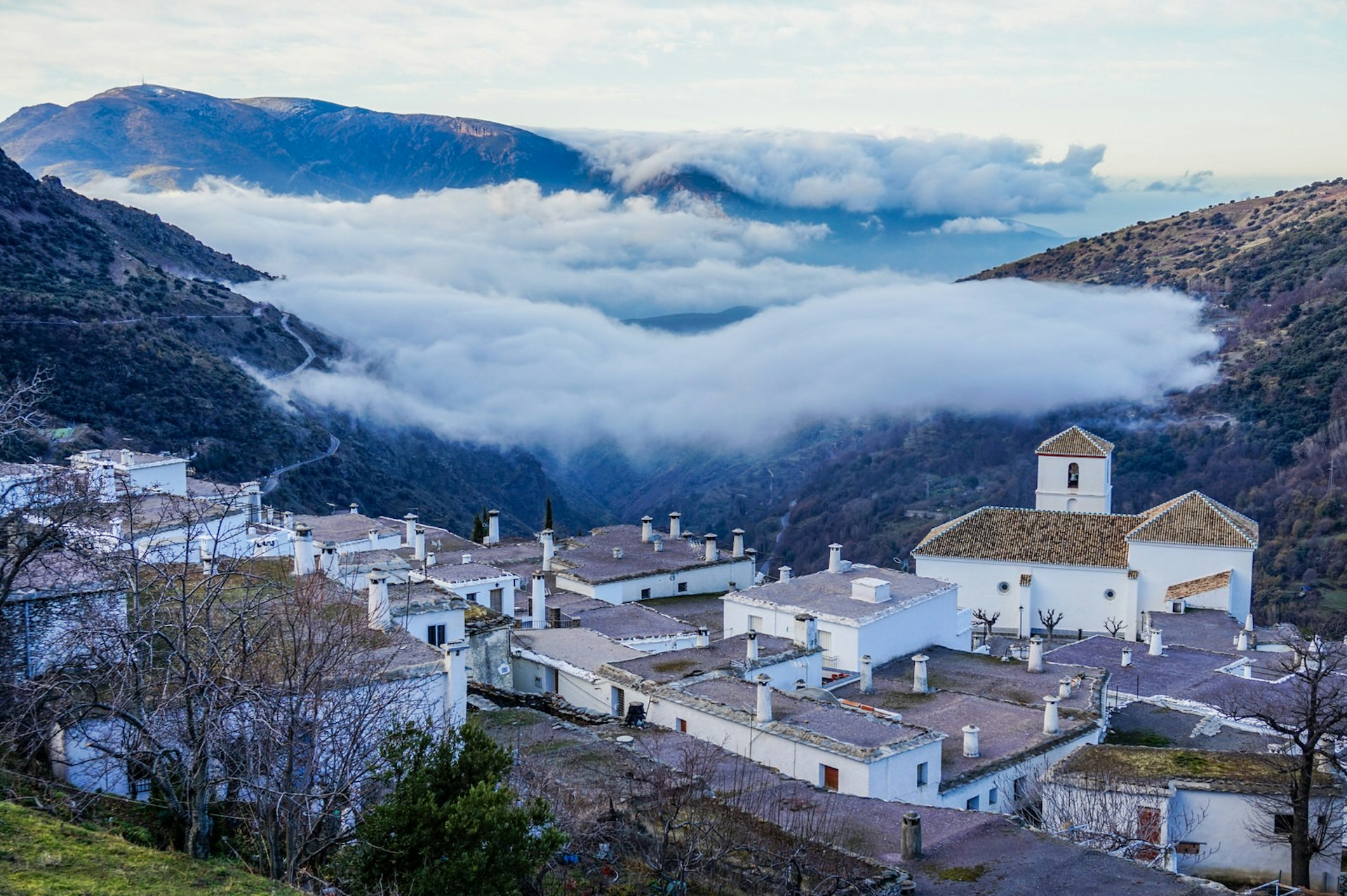 The village of Bubión hovering above the early morning clouds © Brendan Sainsbury / Lonely Planet 